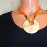 Mutatós narancssárga színű nyaklánc medállal (bizsu) fotó