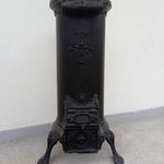 antik vaskályha henger alakú vas kályha kandalló sárkány díszítéssel fotó