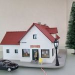 EL12 H0 1: 87 Piko pékség épület érkező vásárlóval, járművel, kültéri kandelláber világítással fotó